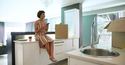 Multiracial Couple Unpacking in Modern Kitchen During Move-In