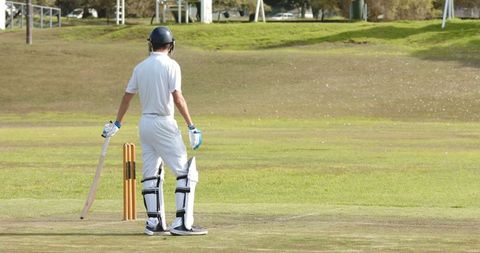 Cricketer Standing on Pitch with Bat Facing Stumps