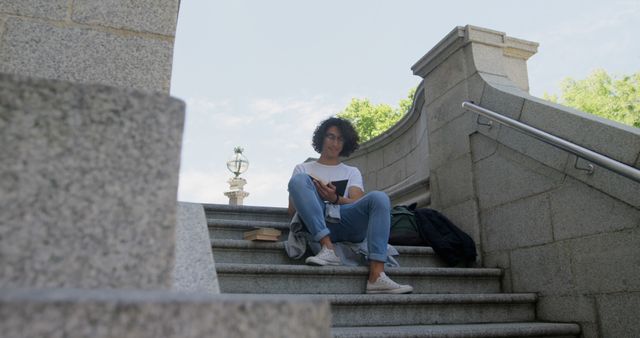 Young Person Studying Alone on Outdoor Stone Steps - Download Free Stock Images Pikwizard.com