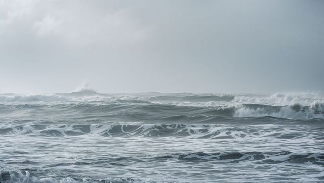 Moody turbulent ocean waves with whitecaps and spray, rolling bands of rough sea, stormy sky