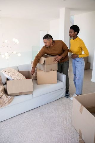 Couple Unpacking Boxes in Modern Living Room during Move
