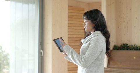 Woman engaging with tablet in minimalist living space