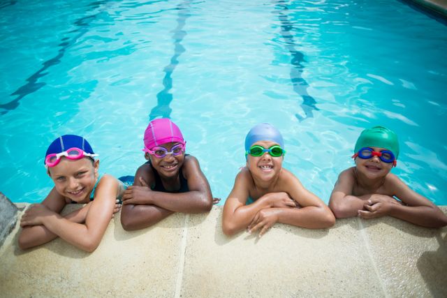 Portrait of little swimmers leaning at poolside