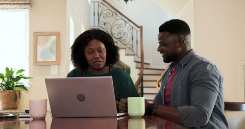 African American Couple Using Laptop and Discussing Financial Plans