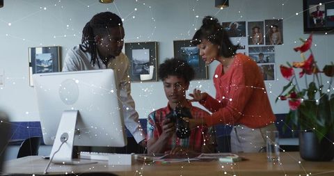 Creative team analysing camera outputs in modern studio environment