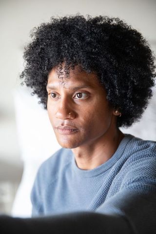 Introspective African American Man Sitting in Cozy Living Room