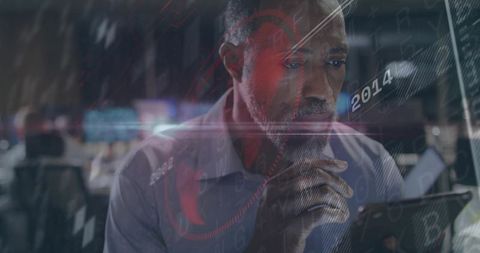 Mature analyst studying tablet with futuristic data overlays in busy office