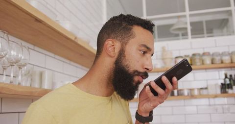 Man Engaging with Smartphone in Modern Kitchen Environment
