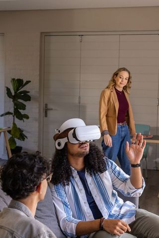 Multicultural friends experiencing virtual reality on couch in modern home lounge