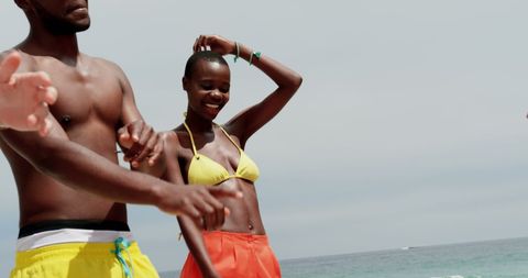 Friends Having Fun on Sunny Beach in Colorful Swimwear