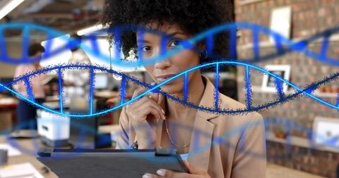 Contemplating businesswoman holding tablet and touching chin with dna overlay in office