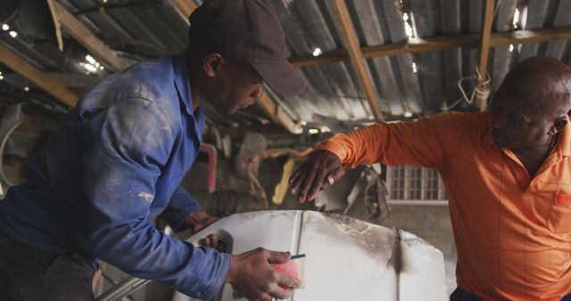 Male Workers Sanding and Inspecting Object in Workshop - Download Free Stock Images Pikwizard.com