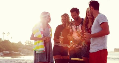 Cheerful Friends Enjoy Sunset Barbecue at the Beach