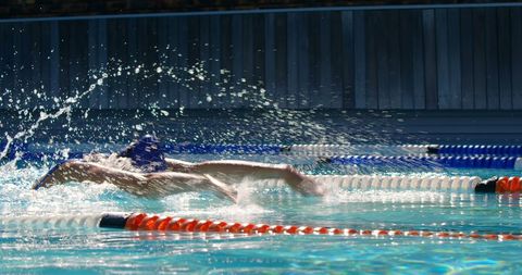 Competitive woman swimming butterfly stroke in pool race