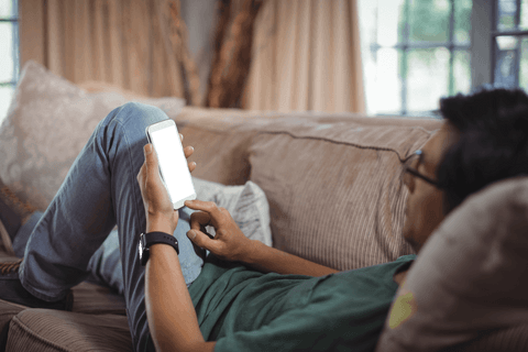 man relaxing on sofa using mobile phone with transparent screen - Download Free Stock Videos Pikwizard.com