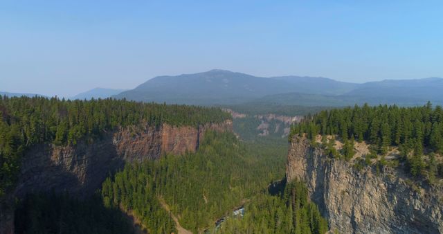 Aerial View of Forested Mountains with Rocky Cliffs on Clear Day - Download Free Stock Images Pikwizard.com