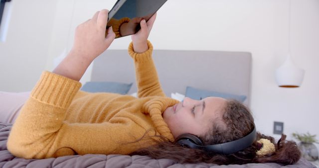 Young Girl Relaxing on Bed with Tablet and Headphones - Download Free Stock Images Pikwizard.com