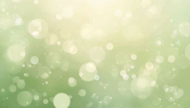 Dreamy soft green bokeh with cream light halos, pastel glowing orbs and gentle haze
