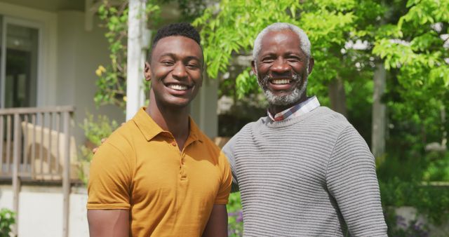 Portrait of happy african american grandfather with adult son in sunny garden - Download Free Stock Photos Pikwizard.com