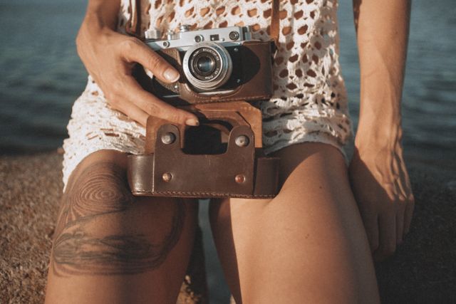 Perfect for articles or blogs about vintage photography, summer lifestyles, outdoor activities, and retro hobbies. May also be used in advertisements for cameras, film photography, or travel content.