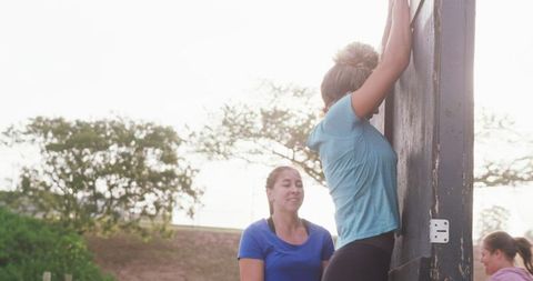 Women helping each other during outdoor fitness boot camp