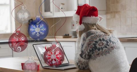 Festive Woman Using Laptop at Christmas with Ornament Overlay