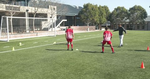 Youth soccer team practicing with coach on sunny day