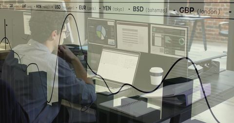 Businessman Analyzing Financial Data on Multiple Screens in Office