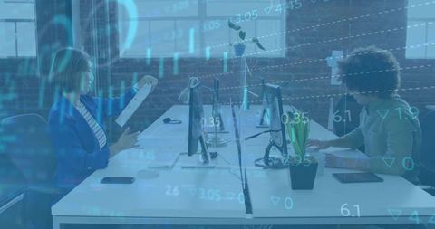 Collaborating at shared workspace, analyzing financial data overlay on desktop monitors