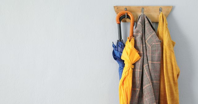 A practical and decorative coat rack displays weather-ready accessories against a simple backdrop. - Download Free Stock Photos Pikwizard.com