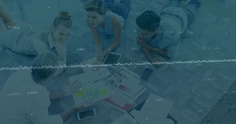 Creative team collaborating over design mockups and swatches with subtle data overlay