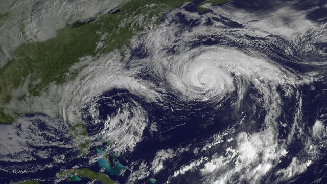 This satellite image shows Hurricane Joaquin in the Atlantic Ocean, north of Bermuda, taken on October 5, 2015. This image captured by GOES East highlights the distinct spiral pattern of the storm, with clouds covering a significant portion of the ocean and reaching near the southeastern United States. Ideal for use in weather reports, climate studies, educational materials on natural disasters, or articles about historical hurricanes.