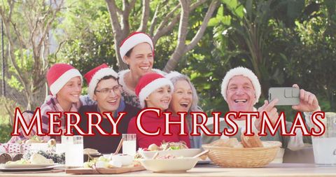 Joyful Family Celebrating Christmas Outdoors with Santa Hats