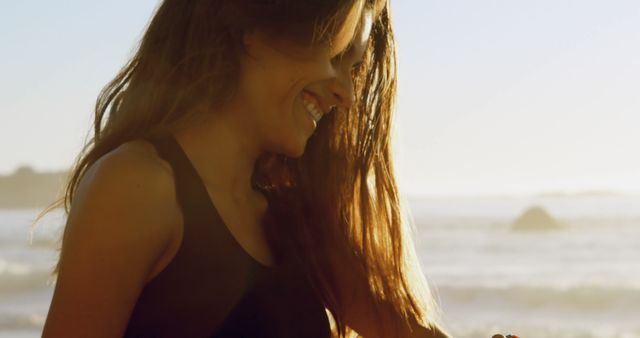 Smiling woman enjoying sunset at beach - Download Free Stock Images Pikwizard.com