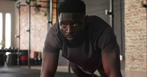 Athletic Man Exercising Plank Position in Gym