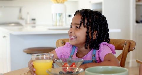 African american girl enjoying breakfast in bright kitchen