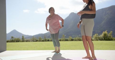 Women Exercising on Mats with Scenic Mountain Views