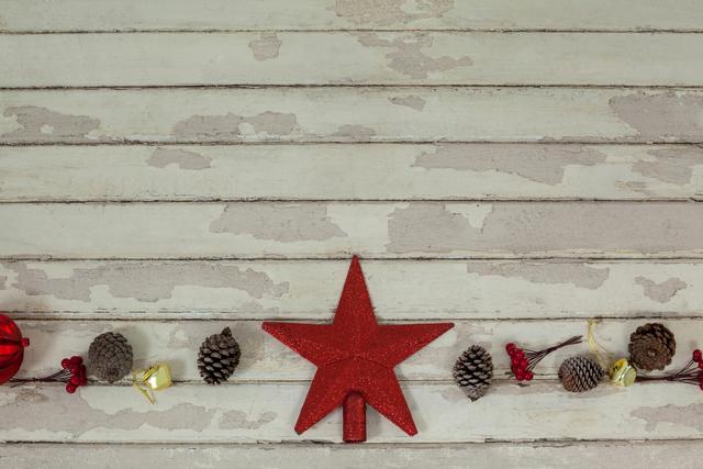 Christmas star decoration with pine cones on rustic wooden plank. Ideal for holiday greeting cards, festive invitations, seasonal advertisements, and winter-themed decor inspiration.