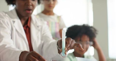 African american teacher demonstrating chemistry demo to children in classroom