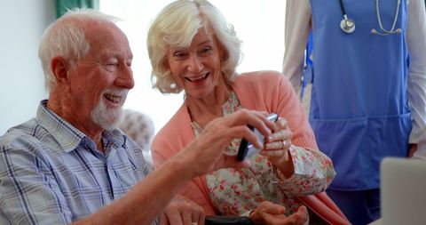 Happy Senior Couple Enjoying Technology in Nursing Home