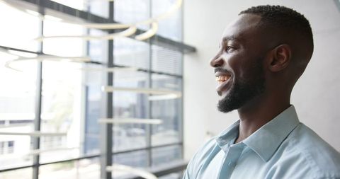 Confident Businessman Smiling in Modern Office with Bright Future