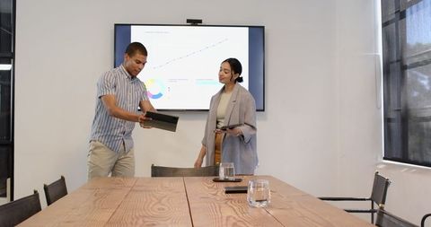 Professionals Collaborating with Technology in Modern Office Meeting