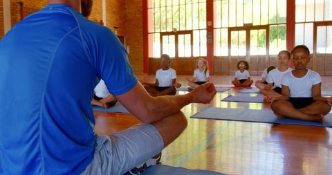 Yoga Instructor Guiding Enthusiastic Children in Meditation Session