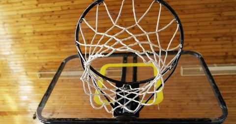 Indoor Basketball Hoop from Below with White Net in Gymnasium