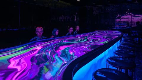 Glowing Marbled Neon Counter Casting Psychedelic Light in Futuristic Nightclub Bar