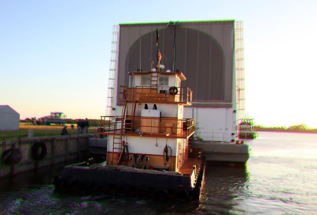 CAPE CANAVERAL, Fla. –This 3-D image shows the tugboat, Miss Alexandra, beginning to push the Pegasus Barge away from the dock at the Turn Basin in the Launch Complex 39 area at NASA's Kennedy Space Center in Florida. The 266-foot-long and 50-foot-wide barge will be towed by NASA's Freedom Star ship to deliver space shuttle main engine (SSME) ground support equipment to Stennis Space Center near Bay St. Louis, Miss. Since being delivered to NASA in 1999, Pegasus sailed 41 times and transported 31 shuttle external fuel tanks from Michoud Assembly Facility near New Orleans to Kennedy. To view this image, use green and magenta 3-D glasses.     The barge is leaving Kennedy, perhaps for the final time. Both the barge and shuttle equipment will remain in storage until their specific future uses are determined. The SSMEs themselves will be transported to Stennis separately for use with the agency's new heavy-lift rocket, the Space Launch System. The work is part of the Space Shuttle Program’s transition and retirement processing. For more information about Shuttle Transition and Retirement, visit http://www.nasa.gov/mission_pages/transition/home/index.html. Photo credit: NASA/Frankie Martin