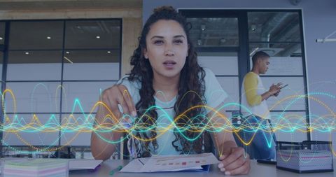 Biracial businesswoman analyzing data with digital interface overlay