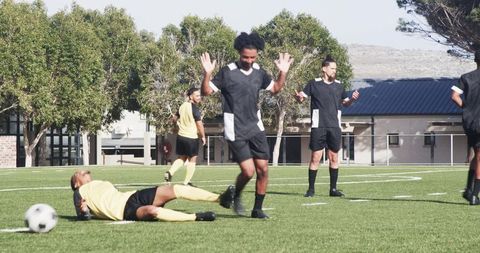 Soccer players supporting teammate on field illustrating sportsmanship