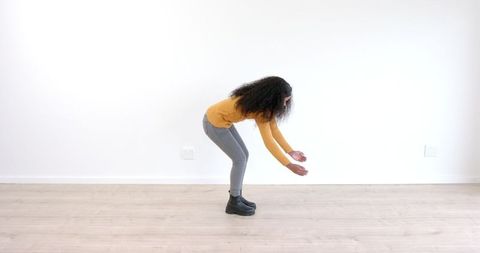 Woman Stretching on Wooden Floor in Casual Attire