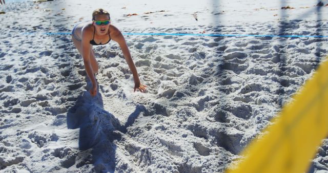 Female beach volleyball player diving for ball during match - Download Free Stock Images Pikwizard.com